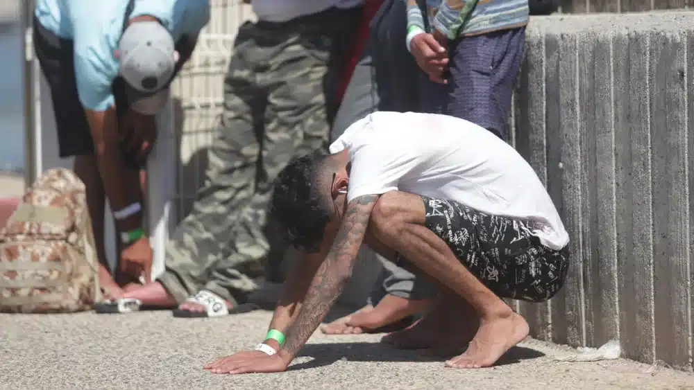 Archivo - Un inmigrante rescatado se apoya en el suelo durante el rescate de 31 magrebíes, diez menores, de una patera en aguas de Barbate, a 23 de septiembre de 2022 en Cádiz (Andalucía, España). - Nono Rico - Archivo