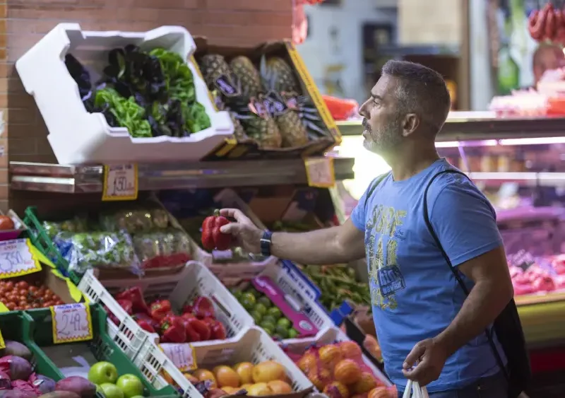 Archivo - Un hombre comprando en un mercado de abastos de Triana (Sevilla). - María José López - Europa Press - Archivo