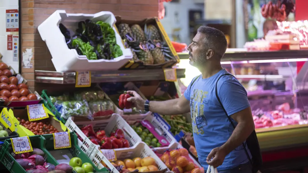 Archivo - Un hombre comprando en un mercado de abastos de Triana (Sevilla). - María José López - Europa Press - Archivo